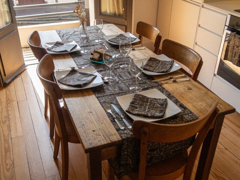 Chemin de table aux motifs bogolan noir et dorés, accompagné de ses serviettes assorties
