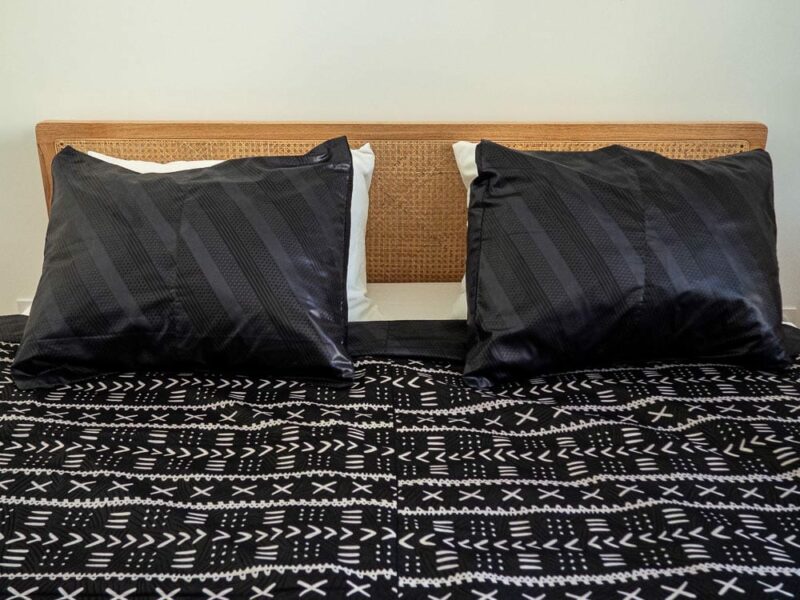 Parure de lit noire avec des motifs ouest africains emblématiques avec une housse de couette et des coussin assortis en wax