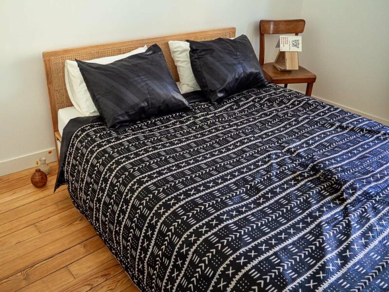 Parure de lit noire avec des motifs ouest africains emblématiques avec une housse de couette et des coussin assortis en wax