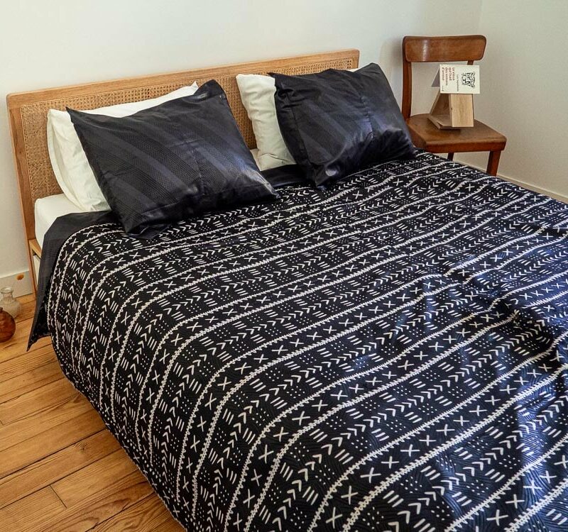 Parure de lit noire avec des motifs ouest africains emblématiques avec une housse de couette et des coussin assortis en wax