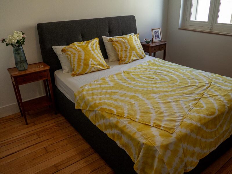 Parure de lit jaune de motifs ouest africains emblématiques avec une housse de couette ou des draps et des coussin assortis.