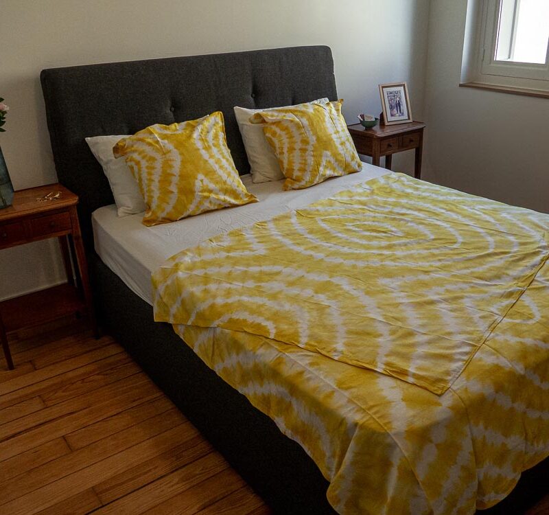 Parure de lit jaune de motifs ouest africains emblématiques avec une housse de couette ou des draps et des coussin assortis.