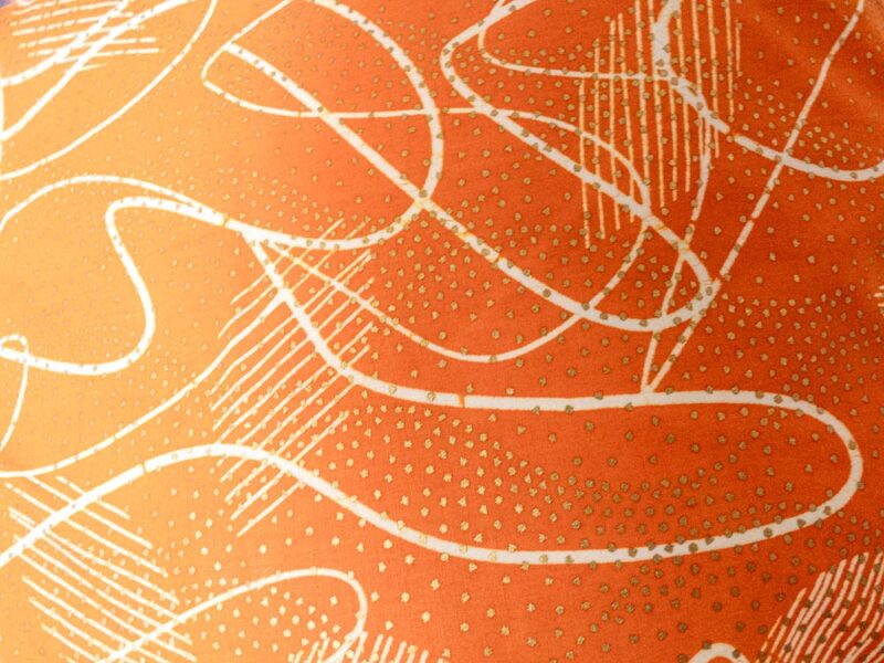 Coussins orange avec motifs blancs et dorés d'Afrique de l'ouest, vu de près