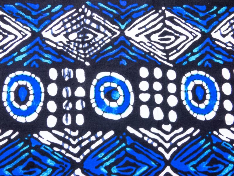 Nappe bogolan noire avec des motifs bleus clair et blancs, vu de près des motifs